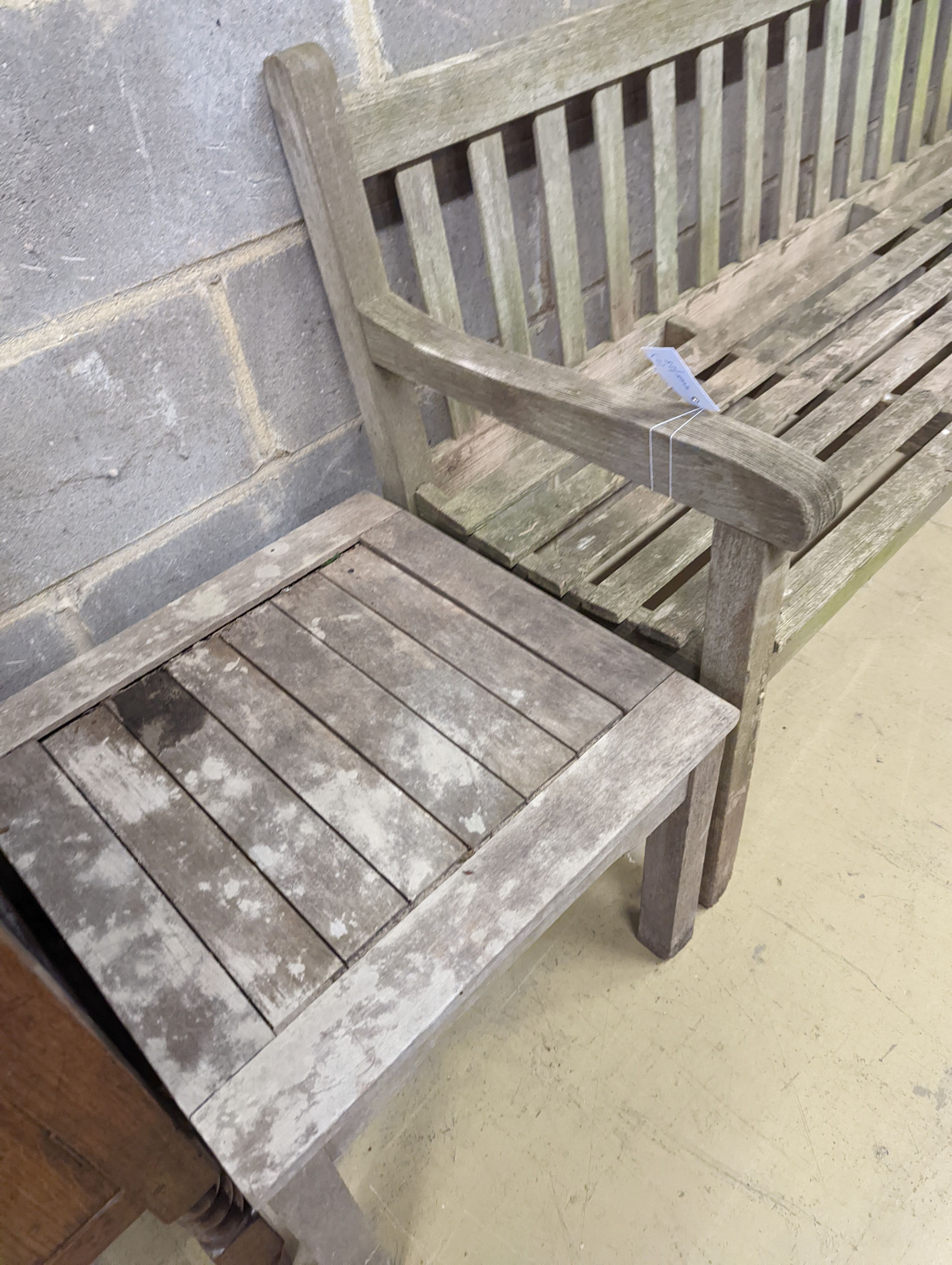 A weathered teak garden bench, length 153cm, depth 50cm, height 79cm and a low square table